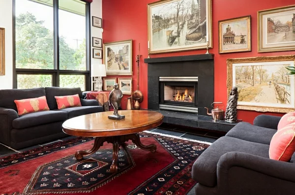eklektisches wohnzimmer rote wand bilder kamin 