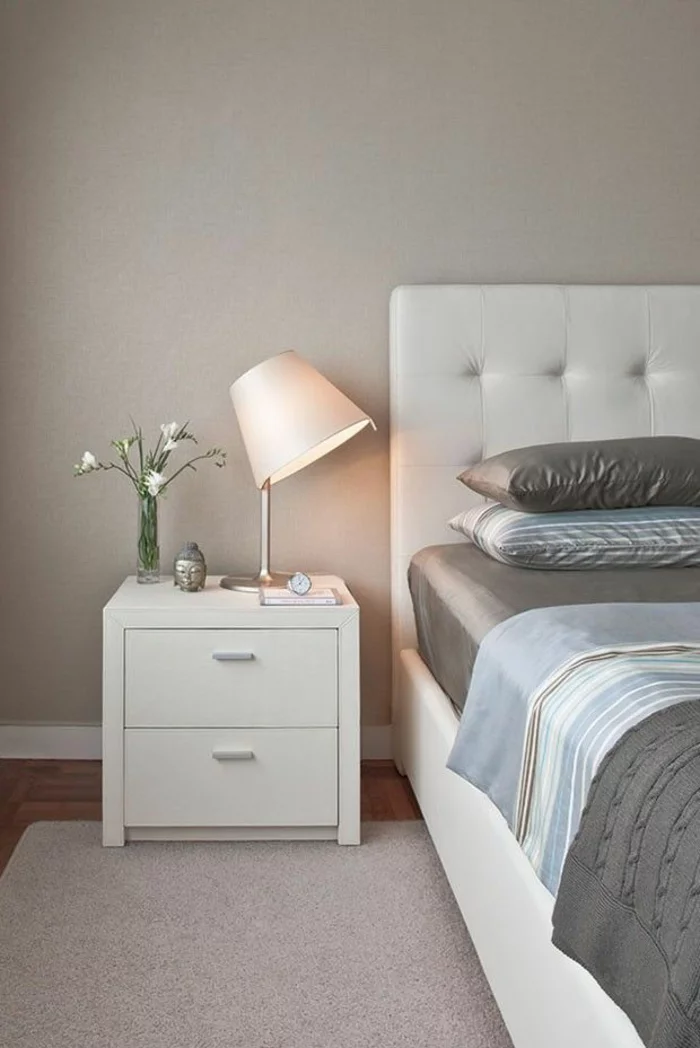schlafzimmer einrichten weißes lederbett weiße nachtkonsole satinbettwäsche