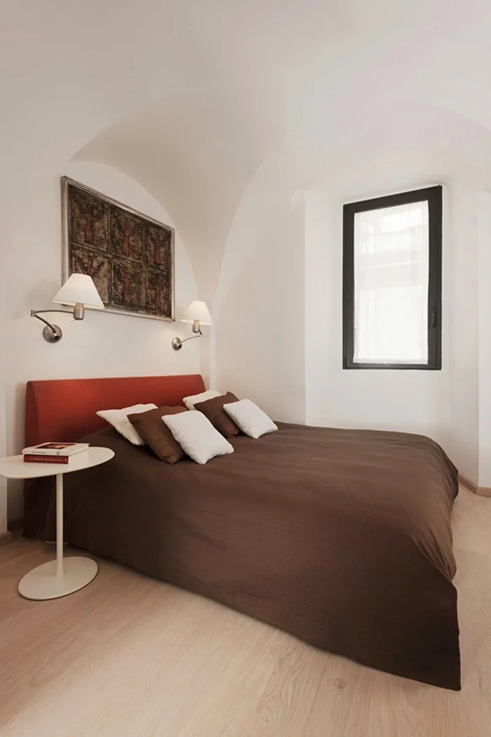 penthousewohnung rom schlafzimmer weiße wände minimalistische inneneinerichtung doppelbett wandleuchten runder beistelltisch