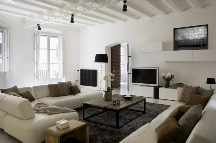 wohnzimmerteppich schwarzer teppich helles mobiliar braune dekokissen