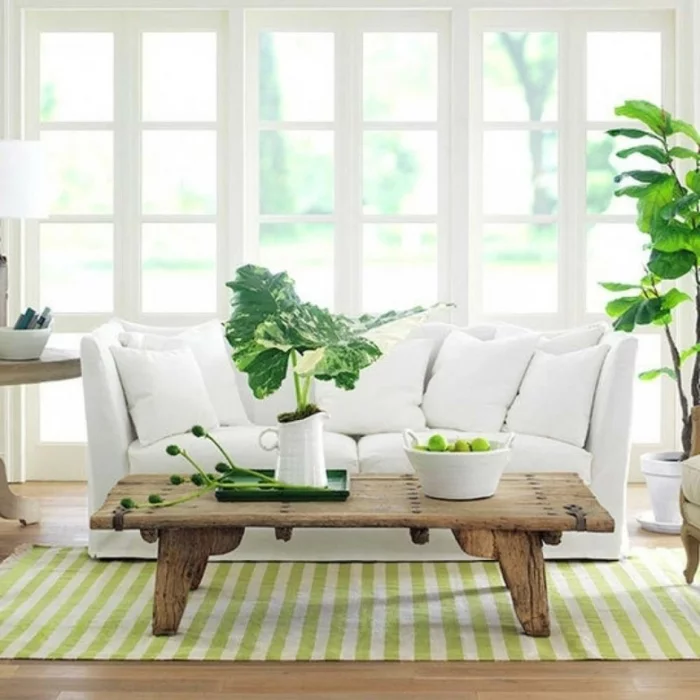 sofa weiß rustikaler couchtisch streifenteppich grüne akzente