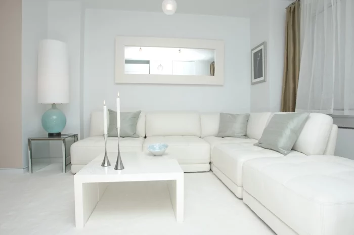 wohnzimmer couch ecksofa weißer teppich kerzen wandspiegel
