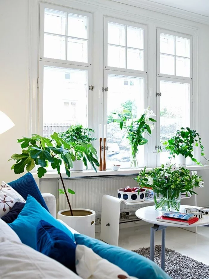 skandinavisch einrichten wohnzimmer blaue dekokissen pflanzen grauer teppich