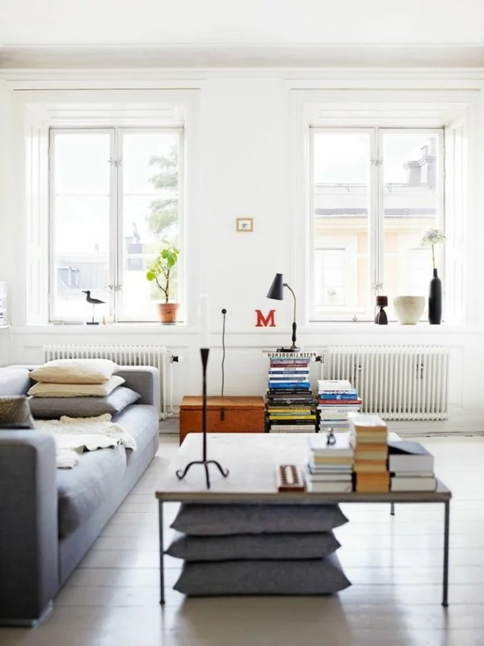 skandinavisch einrichten wohnzimmer design graues sofa dekokissen bücher