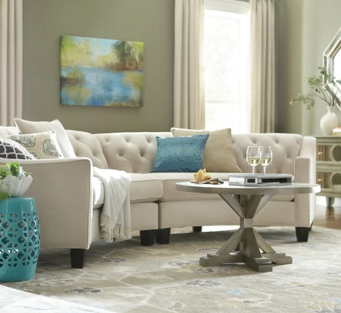 rundes sofa weißes sofa dekokissen blauer beistelltisch schöner teppich