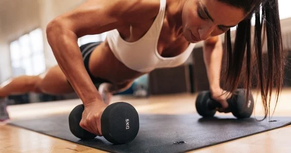 Muskeln aufbauen Fitnessstudio Frau übt gesunde Sporternährung