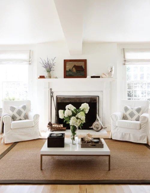 Weiße Hortensien in Vase weiße Raumgestaltung sandgelber Teppich