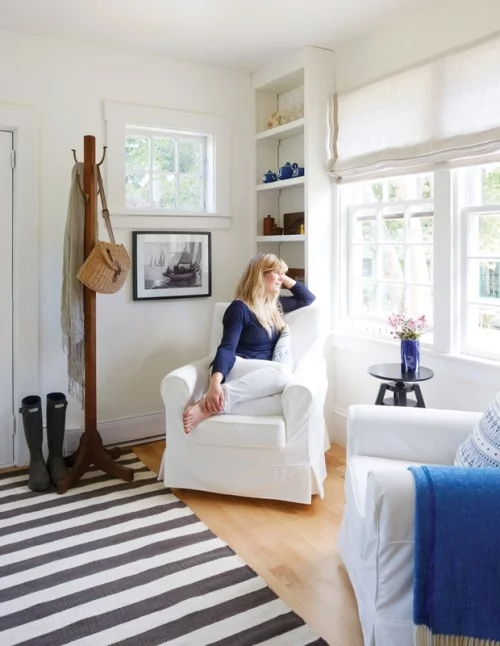 Zimmer in blau-weiß gestaltet gestreifter Teppich Sessel großes Fenster
