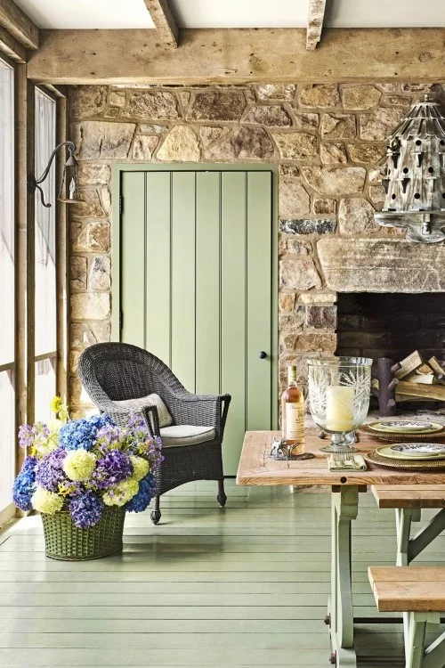 Hellgrün gestrichene Dielen rustikale Steinwand Holzbalken sehr ansprechendes Zimmer Blumen im Korb