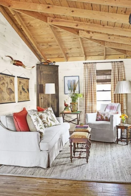 Wohnzimmer im Landhausstil weiße Möbel Zimmerdecke aus Holz bunte Kissen