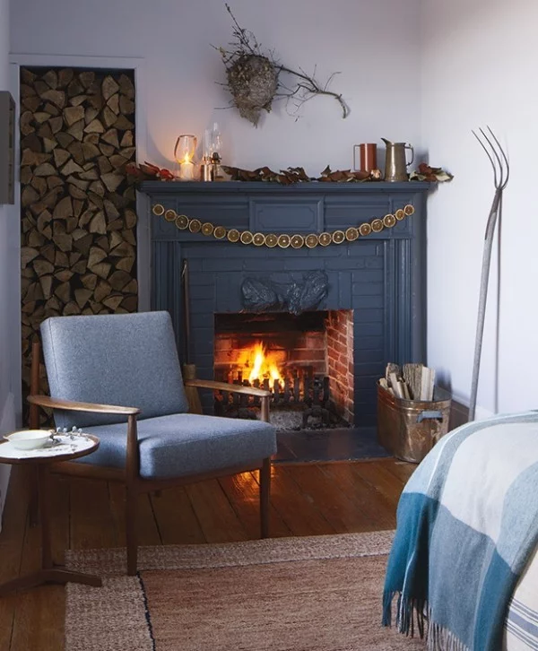 Weihnachten auf dem Lande feiern Sessel Kamin Brennholz Schlafbett sanftes Blau dominierende Farbe