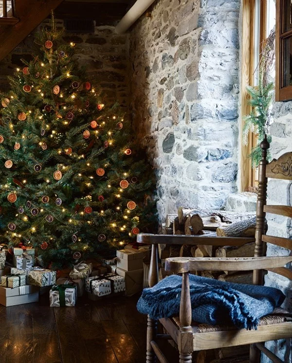 Weihnachten auf dem Lande üppig geschmückter Tannenbaum Steinwand gestapelte Geschenke sanfte Texturen