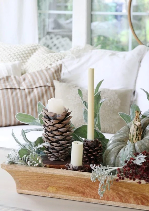Natur ins Haus holen Deko Elemente Zapfen grüne Zweige weiße Kerzen ein winterliches Arrangement