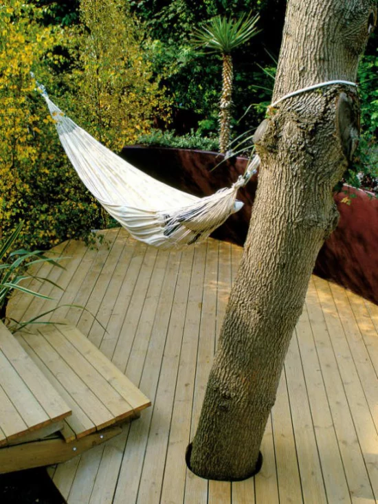 Holzterrasse gestalten hoher Baum Hängematte für puren Relax