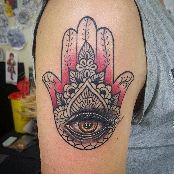 oberarm hamsa tattoo mit auge in rot und schwarz