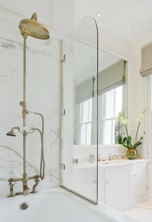 Marmor im Bad Marmorfliesen Badewanne Dusche Glaswand weißes Bad Waschtisch weiße Blumen