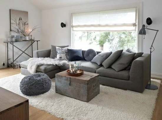 skandinavische wohnzimmereinrichtung mit truhentisch und grauem sofa