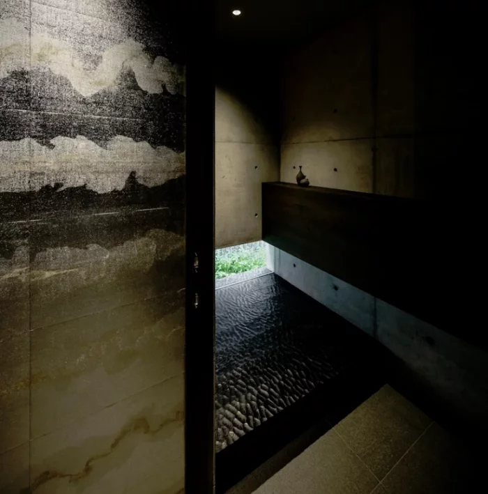 Minimalistisches Haus aus Stein und Beton in Japan Minimalismus pur im Inneren Duschraum als Spa-bereich Natursteinplatten ausgefallene Fliesen dunkles Holz