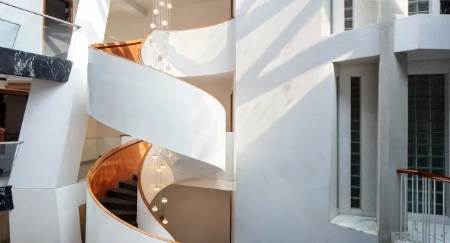 Einzigartiges Hausdesign Cleft House Indien Neu-Delhi elegante Wendeltreppe im Atrium erleichtert den Zugang zu den oberen Etagen
