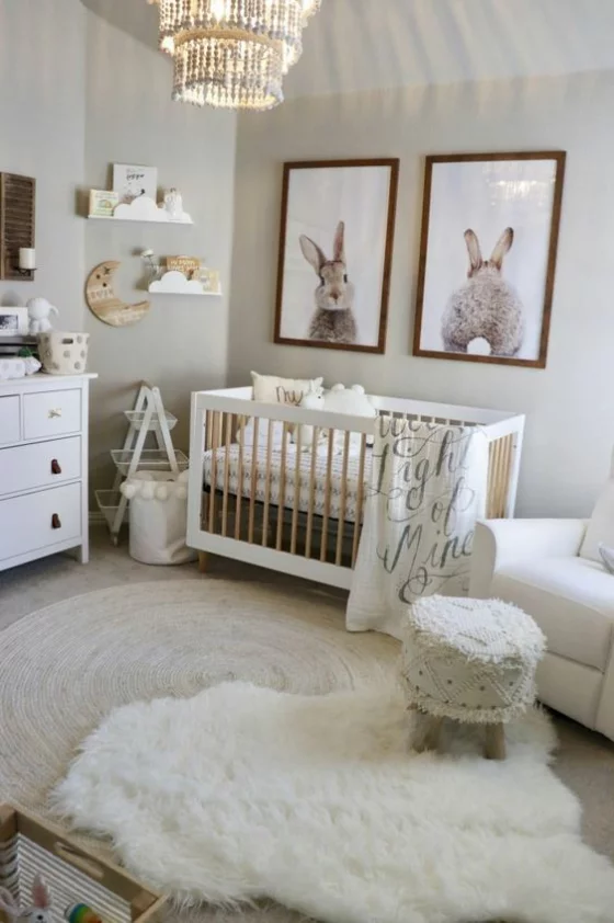 Babyzimmer in Weiß weiche Texturen wenig Wanddeko Hasenzeichnungen in Rahmen