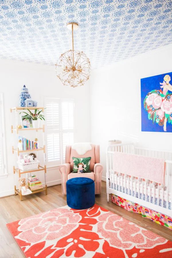 Kunterbuntes Babyzimmer schönes Ambiente marineblauer Hocker Wandbild rosa Akzente