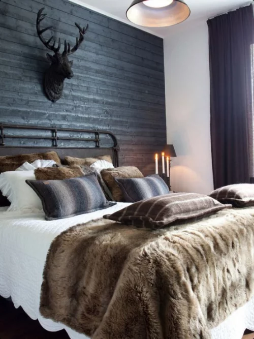 Gemütliches Schlafzimmer im Winter gestalten Decke Kunstfell beige weiße Bettwäsche Hirschgeweih