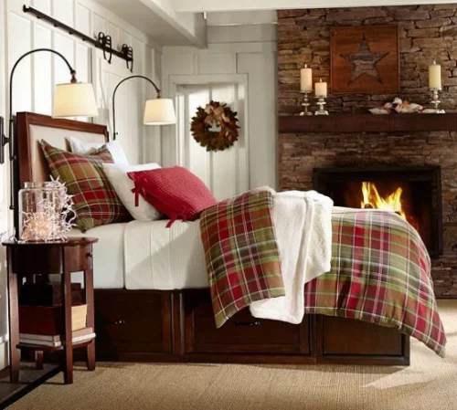 Gemütliches Schlafzimmer im Winter gestalten Kamin Steinwand Karomuster warme Bettwäsche Kissen Lampen