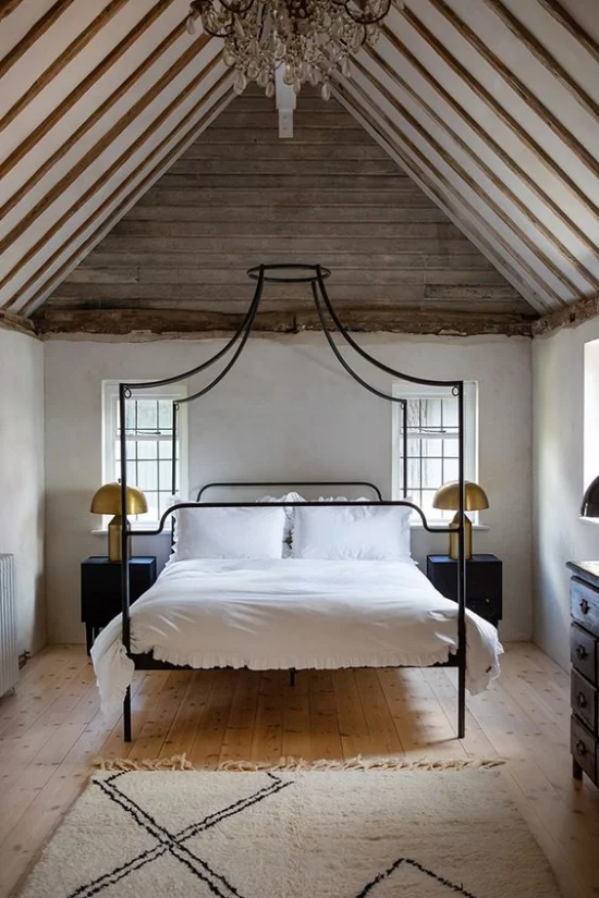 Himmelbett aus Metall weiße Bettwäsche rustikales Schlafzimmer schräge Zimmerdecke